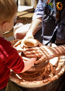 Finestrat, Alicante, İspanya... 23 Nisan 2022: Baba oğluna Gastronomik ve Geleneksel Finestrat Pazarı 'nda çömlekçi ticareti öğretiyor.