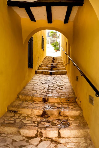 İspanya 'nın Alicante kentindeki Finestrat köyündeki taş merdivenlerle dar geçitli.