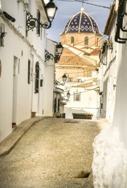 Altea 'da dar sokaklar ve beyazlatılmış cepheler. Arka planda kilise kubbesi