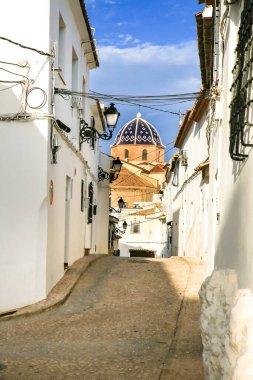 Altea 'da dar sokaklar ve beyazlatılmış cepheler. Arka planda kilise kubbesi