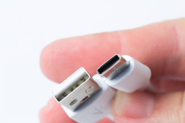 Beyaz arkaplanda el ele tutuşan USB-C Tip kablo bağlantısı