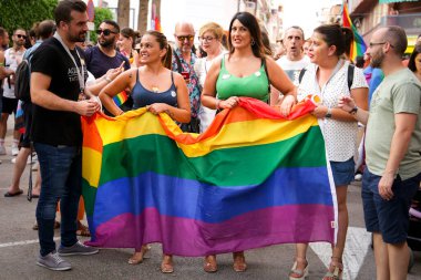 Santa Pola, Alicante, İspanya - 2 Temmuz 2022: İspanya Gay Onur Yürüyüşü 'ne gökkuşağı bayrakları, afişler ve renkli kostümlerle katılıyor