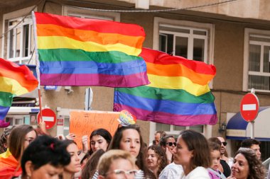 Santa Pola, Alicante, İspanya - 2 Temmuz 2022: İspanya Gay Onur Yürüyüşü 'ne gökkuşağı bayrakları, afişler ve renkli kostümlerle katılıyor