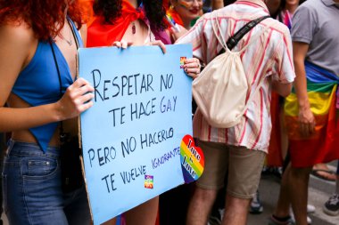 Santa Pola, Alicante, Spain- July 2, 2022: Spanish People attending Gay Pride Parade with rainbow flags, banners and colorful costumes