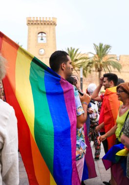 Santa Pola, Alicante, İspanya - 2 Temmuz 2022: İspanya Gay Onur Yürüyüşü 'ne gökkuşağı bayrakları, afişler ve renkli kostümlerle katılıyor