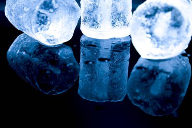 Big Ice cubes and reflections on black background