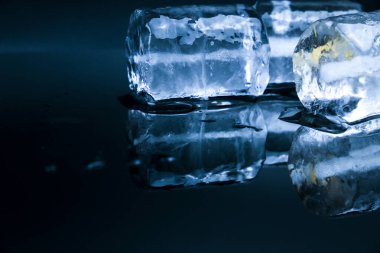 Big Ice cubes and reflections on black background