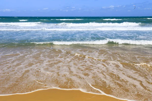 Waves drawing geometric shapes on the shore on the beach in Spain