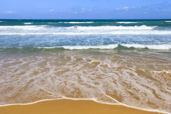 Waves drawing geometric shapes on the shore on the beach in Spain