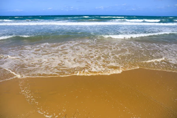 Waves drawing geometric shapes on the shore on the beach in Spain