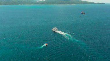 Deniz üzerinde paraşütle uçan turistler. Boracay, Filipinler