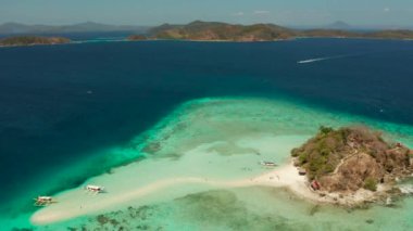 Beyaz kumlu sahili olan küçük torpik bir ada..