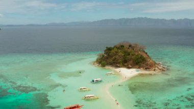 Beyaz kumlu sahili olan küçük torpik bir ada..