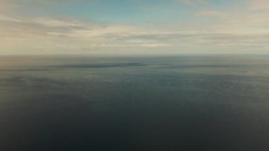 Deniz manzarası, mavi deniz, bulutlu ve adalı gökyüzü.