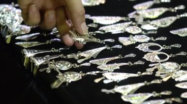 Bir kadın mücevher dükkanından küpe seçer..