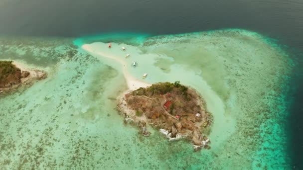 Kis torpic sziget fehér homokos stranddal, felülnézetből.