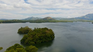 Aerial drone of lake against the background of mountains and tropical vegetation. Loggal Oya Reservoir. Sri Lanka.
