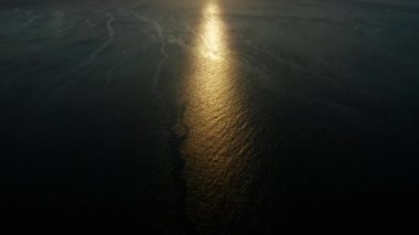 Deniz yüzeyinde günbatımı dalgalarla, hava aracıyla. Su yüzeyine yansıyan güneş. Okyanusun üzerinde gün batımı. Deniz manzarası, yaz ve tatil konsepti