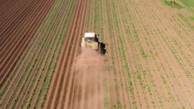Patates tarlası manzaralı traktör Hilling Patatesleri. Toprak hazırlayan ve gübre üreten çiftçiler