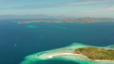 Ditaytayan adasındaki tropikal plajlar. Beyaz kum çubuğu, palmiye ağaçları ve yeşil tepeleri olan tropikal bir ada. Seyahat konsepti. Palawan, Filipinler