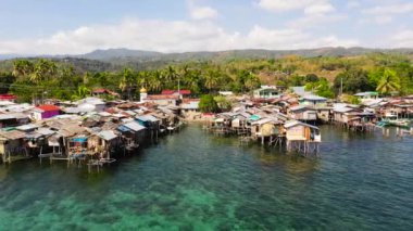 Asya 'da balıkçı tekneleri ve deniz kenarında evleri olan geleneksel bir balıkçı köyü. Filipinler, Mindanao.