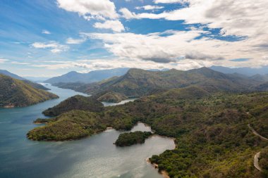 Aerial view of Lake among the mountains against the blue sky and clouds. Randenigala reservoir, Sri Lanka.