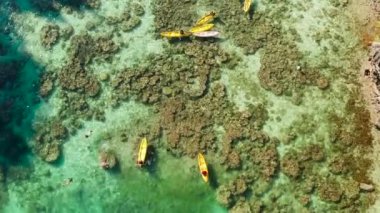 berrak su ile lagün kayık üzerinde turistlerin havadan görünümü. Lagünde şnorkelle yüzme ve kano. Turkuaz suyu olan küçük bir lagün. El nido, Filipinler, Palawan. Yaz ve seyahat tatili