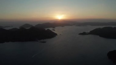 Günbatımında tekneleri olan deniz manzaralı bir yer. Adalarla birlikte denizin üzerinde gün batımı. Akşamları Filipin Adaları. Busuanga, Palawan, Filipinler