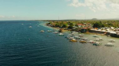 Turistler, açık mavi okyanus suyu ve hava manzarasıyla mercan resifleri üzerinde şnorkelle yüzerler. Moalboal, Filipinler. İnsanlar mercan resifleri arasındaki şeffaf denizde yüzerler. Yaz ve seyahat tatil konsepti.