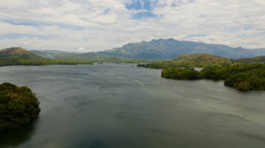 Tropical landscape: A lake against the background of mountains and tropical vegetation. Loggal Oya Reservoir. Sri Lanka.