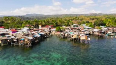 Asya 'da balıkçı tekneleri ve deniz kenarında evleri olan geleneksel bir balıkçı köyü. Filipinler, Mindanao.
