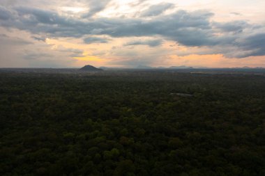 Sri Lanka milli parkındaki dağların arka planında, ormanın üzerinde gün batımının hava manzarası.