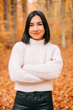 Renkli sonbahar sezonunda ormanda genç bir kadının portresi. Ormanda poz veren mutlu kız..