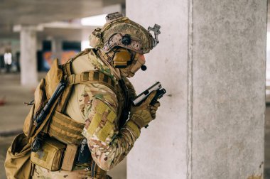 Terk edilmiş binada CQB savaş eğitimi alırken Multicam üniforması ve tabancası xDM 9mm ile özel kuvvetler operatörü. Kentsel çevrede silahlı çakal kahverengi ve MC teçhizatı.