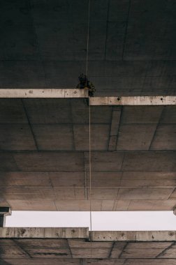 Özel kuvvetler operatörü halatla terk edilmiş binadan iple iniyor. Kahverengi çakallı çoklu kamuflaj..