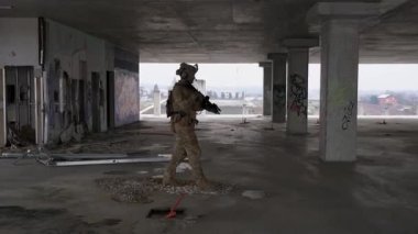 Multicam üniformalı özel kuvvetler operatörü ve saldırı tüfeği HK 416 terk edilmiş binada CQB savaş eğitimi alırken. Kentsel çevrede çakal kahverengi ve MC dişlisi.