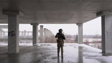 Multicam üniformalı özel kuvvetler operatörü ve saldırı tüfeği HK 416 terk edilmiş binada CQB savaş eğitimi alırken. Kentsel çevrede çakal kahverengi ve MC dişlisi.