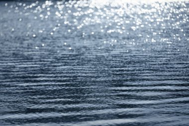 Yumuşak ve pürüzsüz su dalgaları bulanık parlak soyut güneş ışığıyla, açık hava yaz tatili konseptinin arka planının kopyalama alanı.