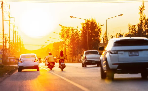 Gün batımında trafik ve asfalt yolu bulanıklaşır. Seyahat ve ulaşım kavramı.