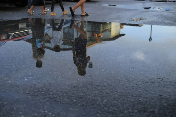 大雨过后的湿车位上 有汽车的倒影 地面上有行人行走的水坑 有选择的焦点 — 图库照片