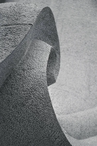 Soyut çizgiler ve granit taşın eğri heykeli. Arka plan için tek renkli doğu tarzı..