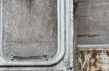 Eski ve paslı tren vagonunun kilitli kapısı, hasarlı metal / grunge dokusu, çizikler ve çatlaklar..
