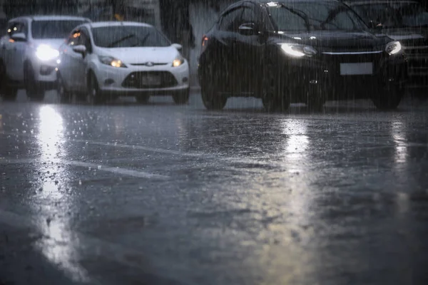 激しい雨の中 忙しい街の通りを長蛇の列になって走る車は夜になります フィールド構成の選択的焦点と浅い深さ — ストック写真