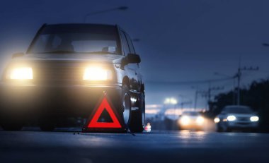 Kırmızı acil durum dur işareti (kırmızı üçgen uyarı işareti) ve kırsal yolda kırık siyah SUV arabası, SUV arabasında seçici sis