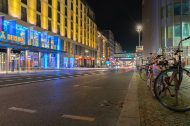 Berlin Almanya - 25 Ağustos 2017; Friedrichstrasse geceleri sokak lambaları ve neon ışıklarıyla aydınlatılarak uzaklığa doğru giden tren rayları.