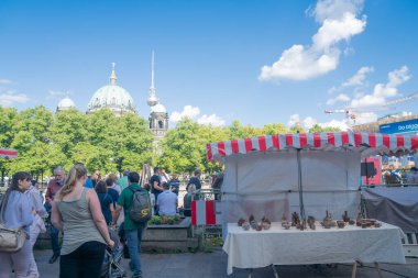 Berlin, Almanya - 28 Ağustos 2017; Katedral ve TV Kulesi kubbesi ve arka planda kuleleri olan şehir sokak pazarlarında öğleden sonra satılık insan ve el sanatları.