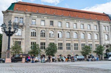 Berlin Almanya - 26 Ağustos 2017; Berlin-Brandenburg Bilim ve İnsani Bilimler Akademisi Jandarma Meydanı 'nda oturan turistlerin arkasındaki bina.