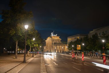 Brandenburg Soğuk Savaş 'ın sembolü, Berlin Almanya' da uzun süre açık kalan gece gökyüzüne karşı güçlü bir şekilde aydınlanmaktadır..