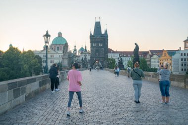 Prag, Çek Cumhuriyeti - 29 Ağustos 2017; Charles Köprüsü 'nün doğuşunda halk ve tarihi heykeller şehir mimarisinin arka planına karşı.