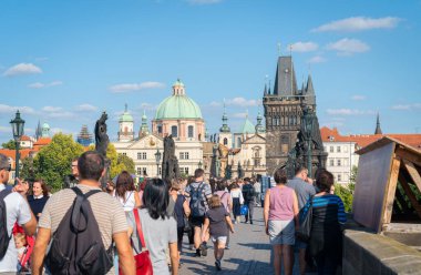 PRAGUE, CZECH REPUBLIC - 29 Ağustos 2017; Turistler ünlü ve tarihi Charles Köprüsü günlük Eski Şehir ve tarihi mimari ve ana köprü kapısı ve ilerideki kule boyunca akın ediyorlar